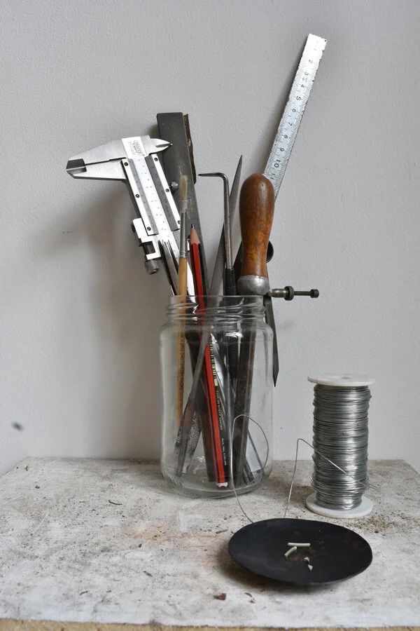 Jeweller's hand tools laid out on a studio workbench